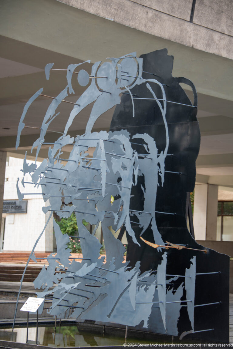 Black-and-white mural of marching figures in Bishkek, Kyrgyzstan.