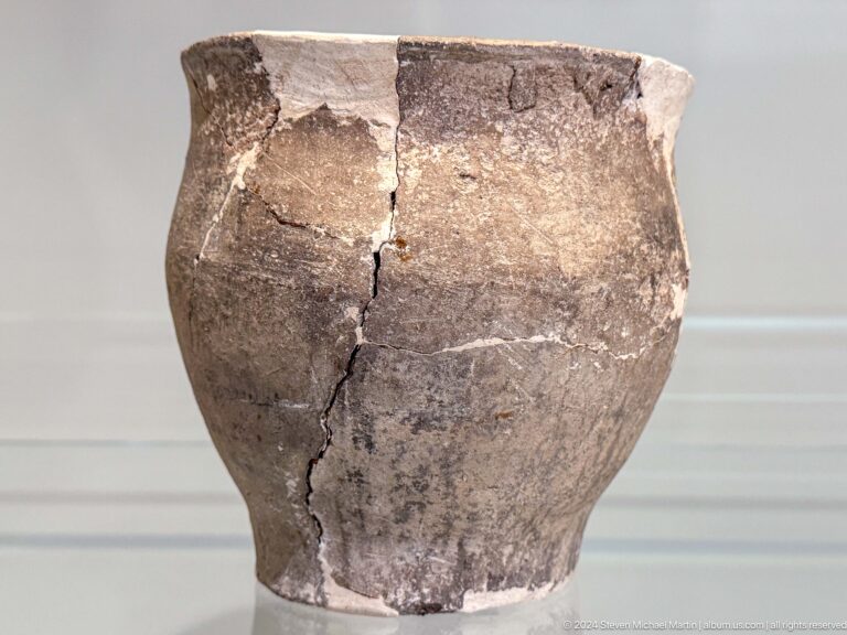 Large reconstructed earthenware jar with repaired cracks.