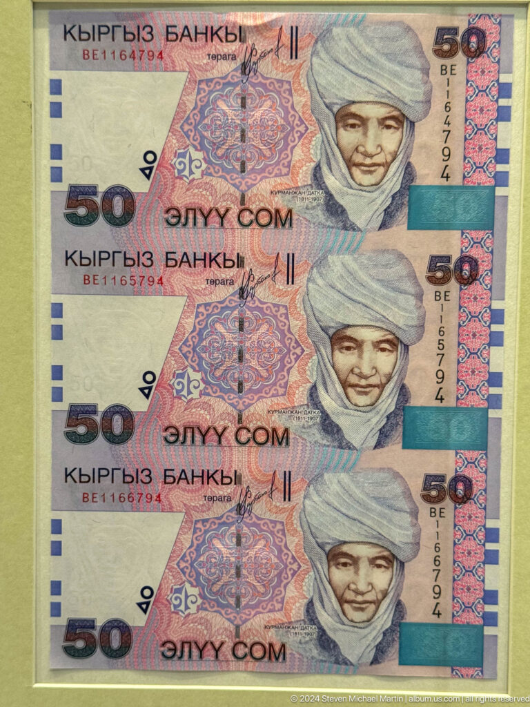 Close view of a purple and orange fifty som banknote.