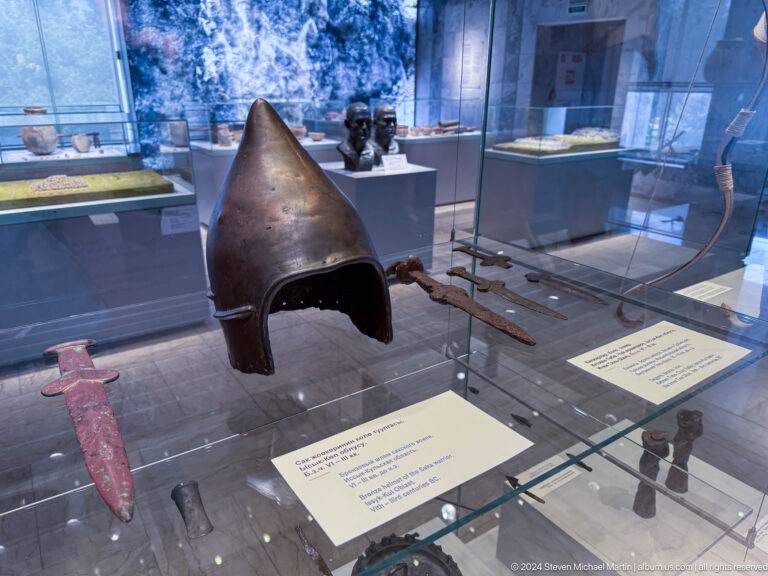 Pointed iron helmet beside a long sword and spearhead.