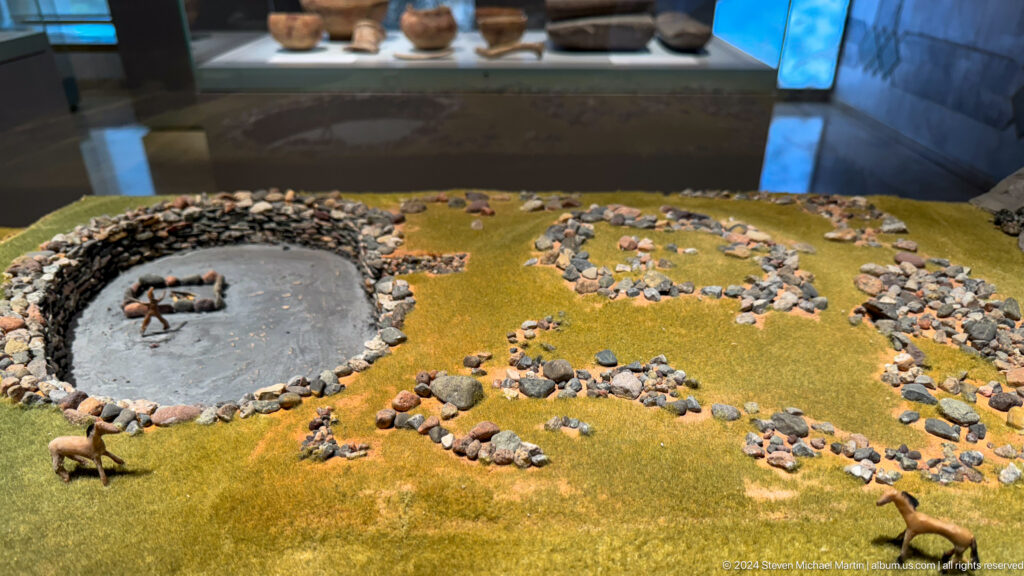 Scale model of a settlement spread across ochre terrain.