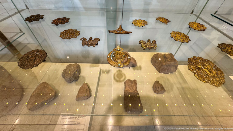 Display case filled with gold jewelry and plaques.
