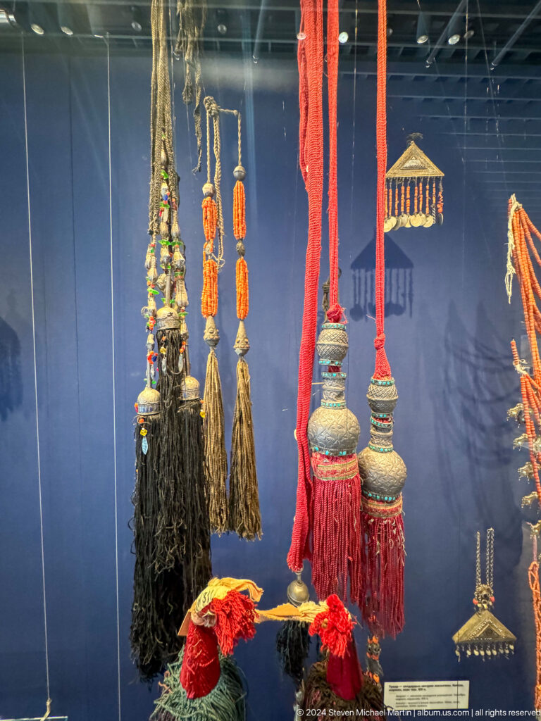 Long hanging ornaments with beads and dark fiber tassels.