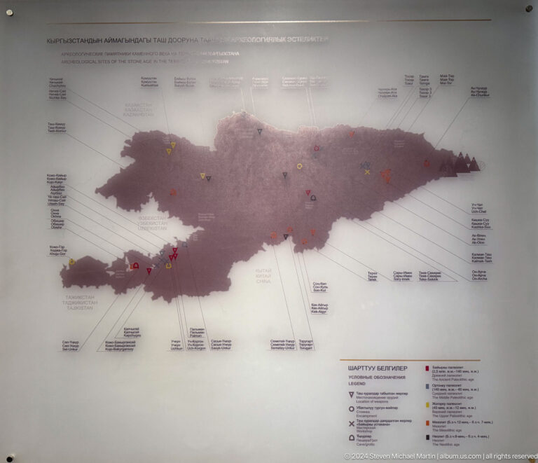 Wall map of Kyrgyzstan in muted red tones.
