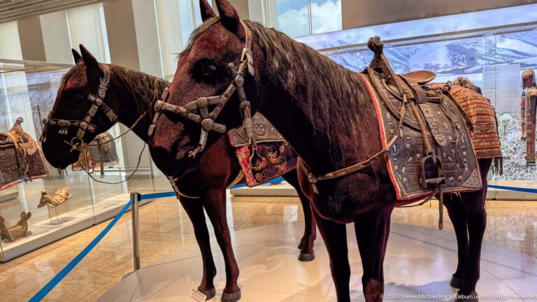 Life-size saddled horse mannequin in gallery.