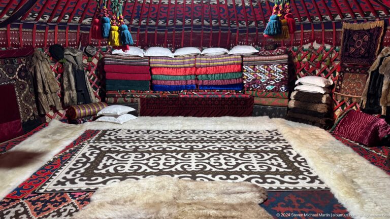 Reconstructed yurt interior with felt carpets and bedding.