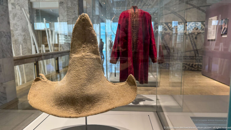 Large pale felt hat beside a red robe.