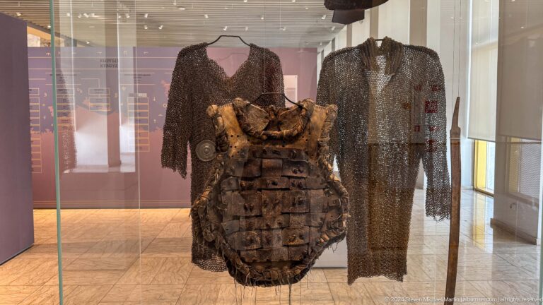 Historic armor and garments displayed upright.