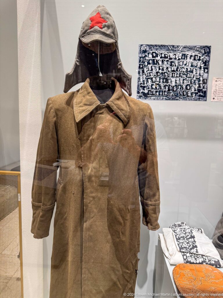 Brown military tunic displayed in glass case.