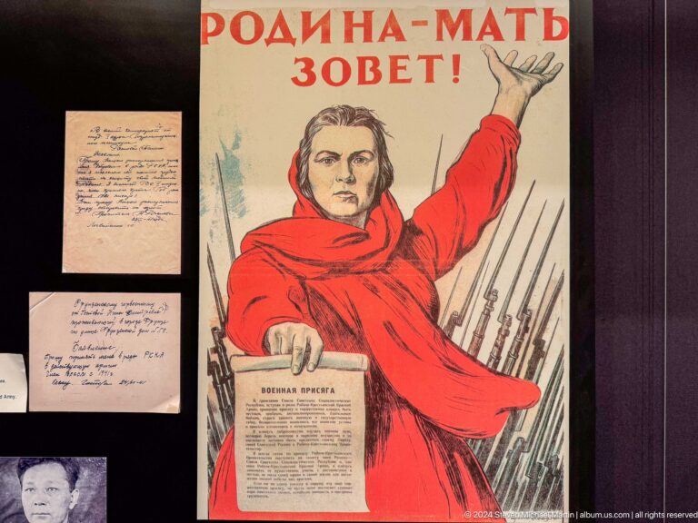 Propaganda poster of woman raising arm beneath Cyrillic text.