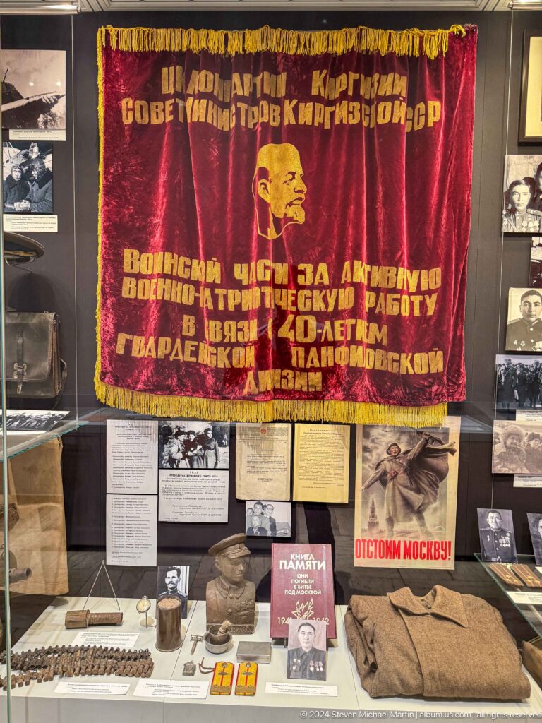 Red banner with gold Cyrillic inscription and Lenin profile.