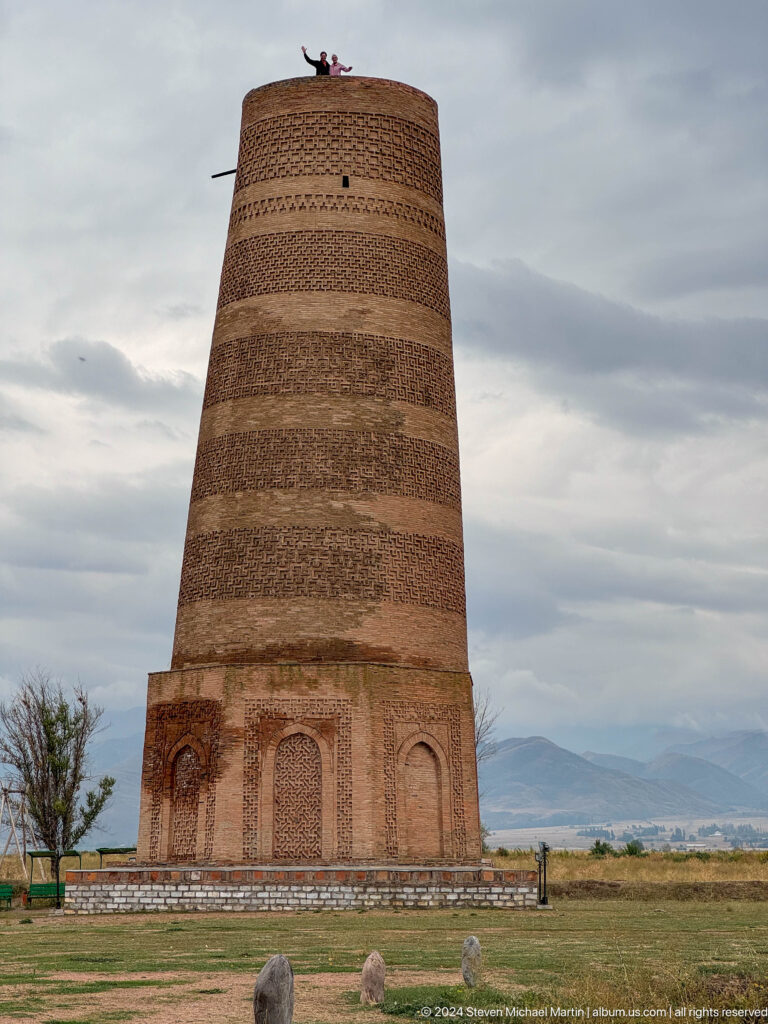 The brick minaret is framed vertically from its decorated base into the patterned shaft