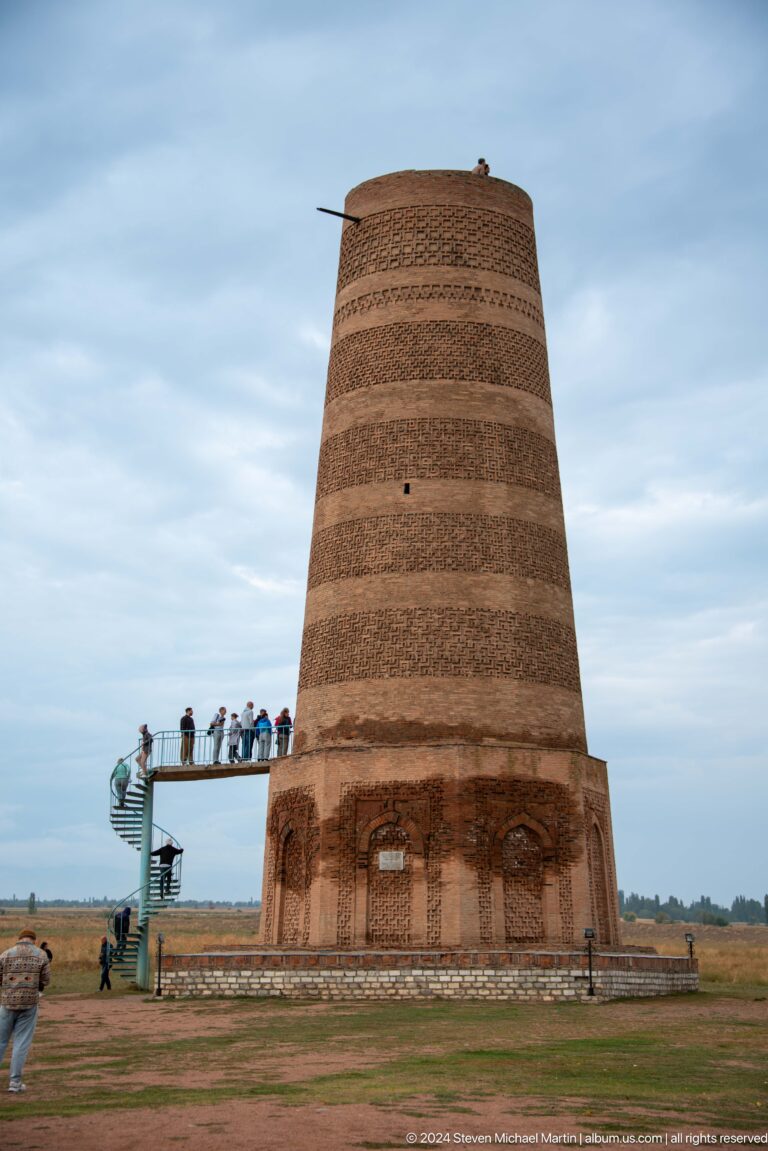 Visitors stand on the raised base of the brick minaret, emphasizing its monumental scale