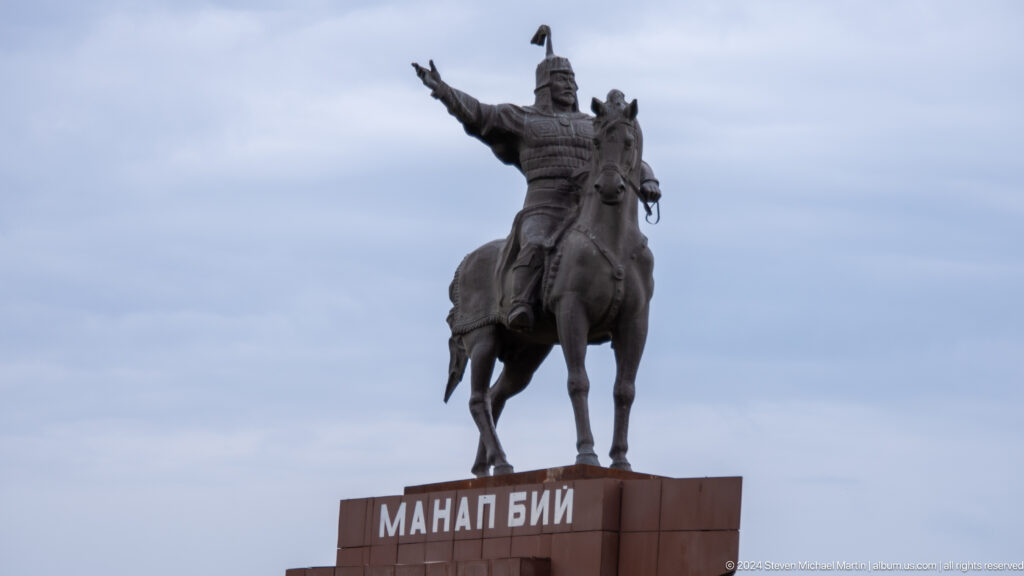 A mounted warrior figure raises one arm while seated on a rearing horse
