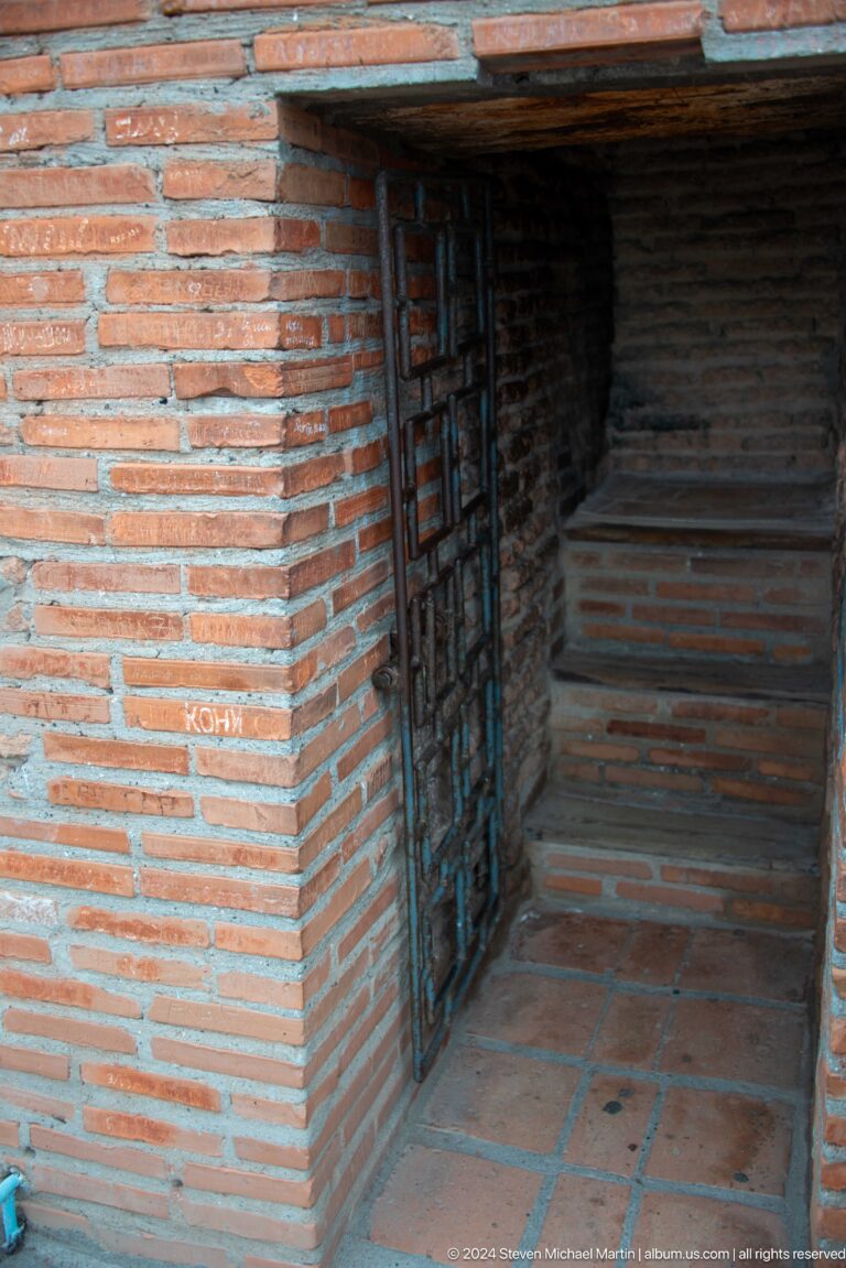 A narrow doorway opens onto steep brick steps within the tower