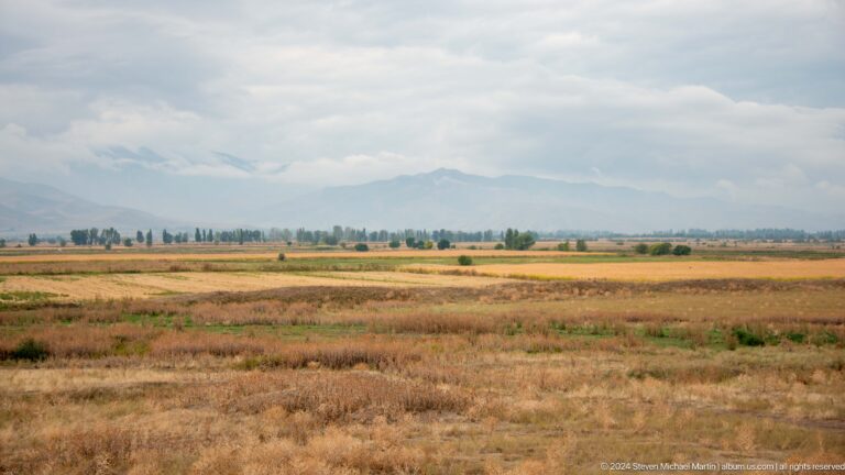 Fields and distant mountains extend across the horizon from an elevated viewpoint