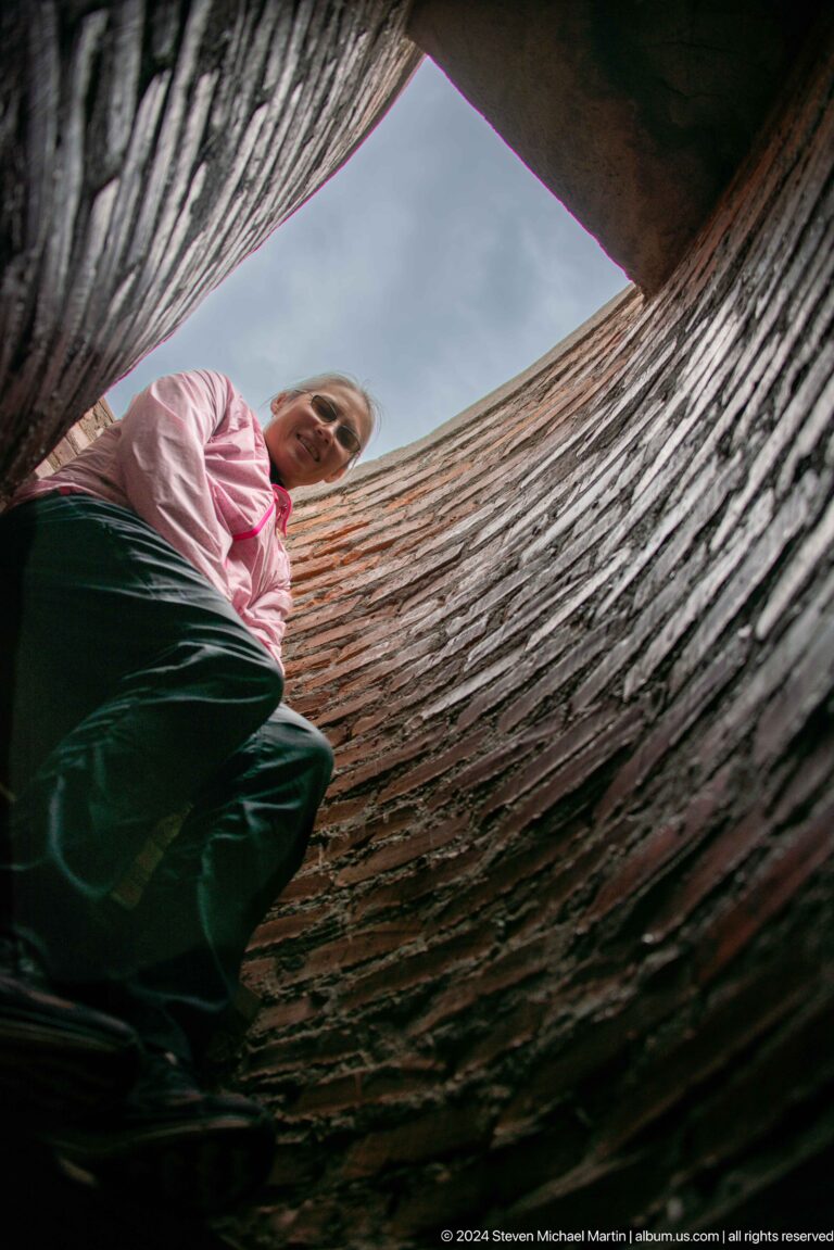 A visitor ascends the steep confined passage of the tower interior