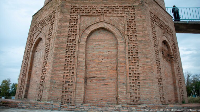 Two recessed panels with arched heads and geometric brick borders fill the lower wall