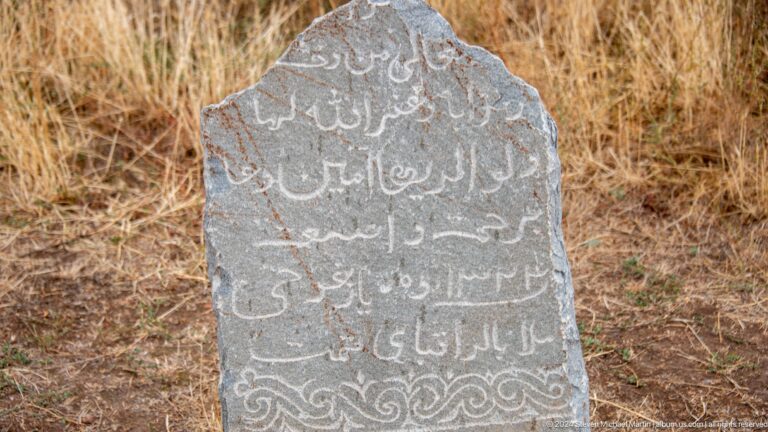 Arabic-script inscription covers the face of an upright stone marker