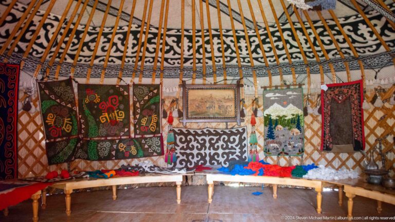 Textiles, framed pictures, and household objects line the circular lattice walls