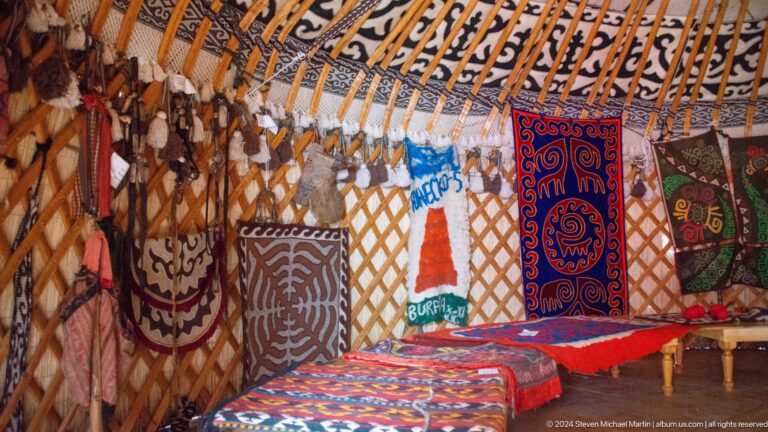 Decorative felt panels, carpets, and hanging objects cover the lattice walls