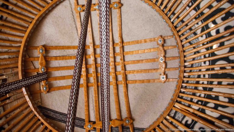 Curved roof poles radiate toward the circular crown above the decorated wall lattice