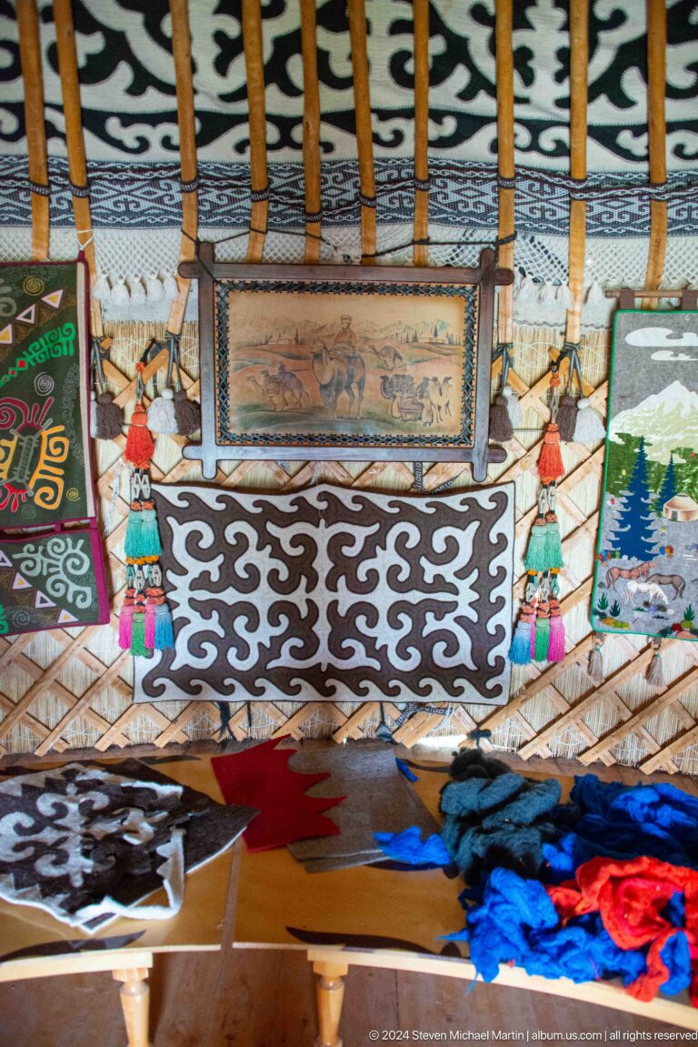 A black-and-white felt panel with scrolling ornament covers a chest or low furnishing