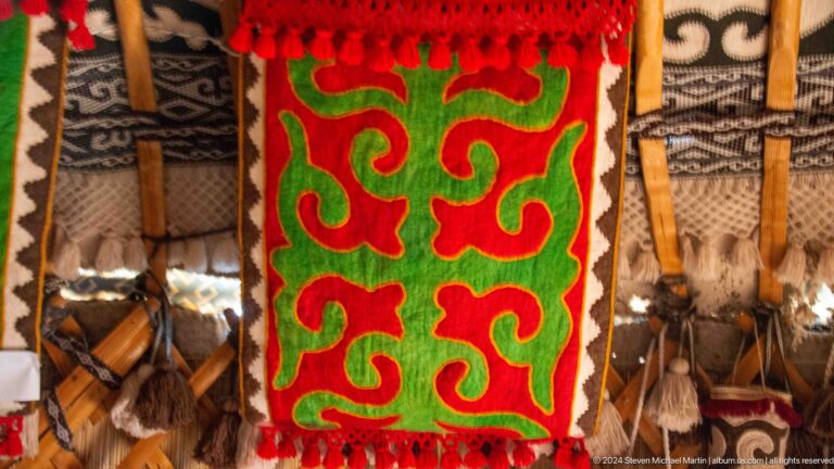 Bold red and green scroll motifs form a symmetrical felt design