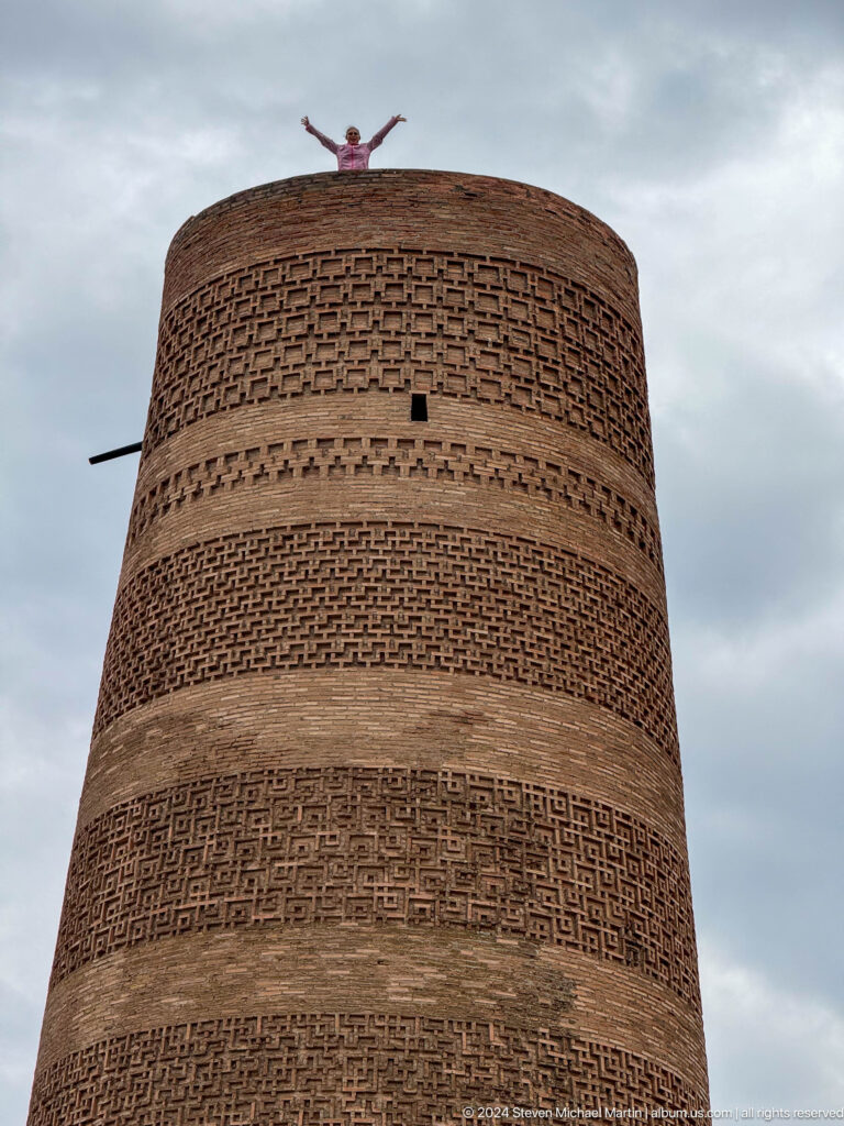Alternating plain and patterned brick bands rise toward the top of the minaret