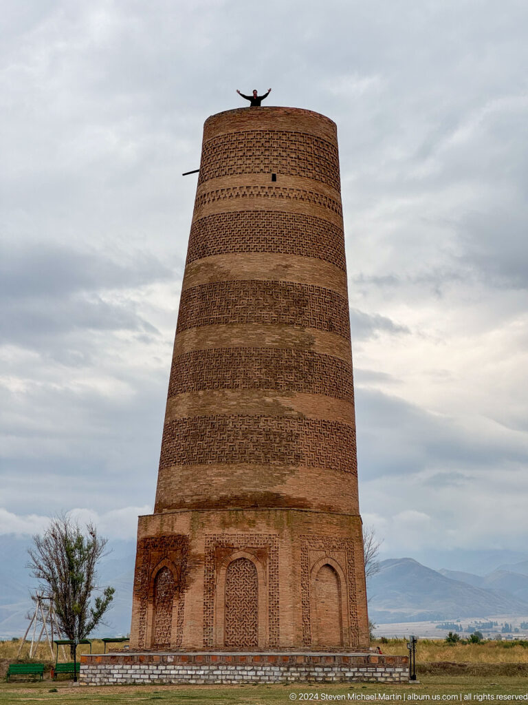 The tapering cylindrical shaft fills the frame beneath a gray sky