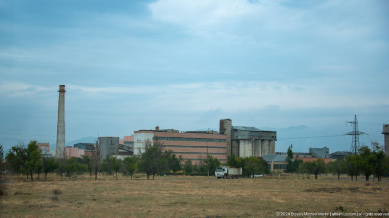 Industrial complex with tall smokestack.