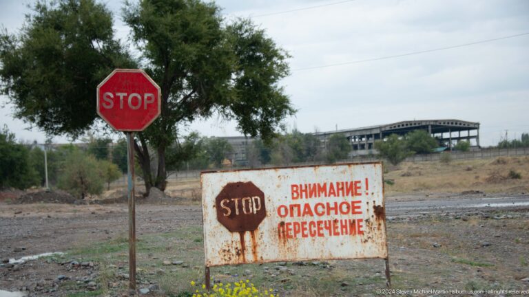 Stop sign beside a warning board.