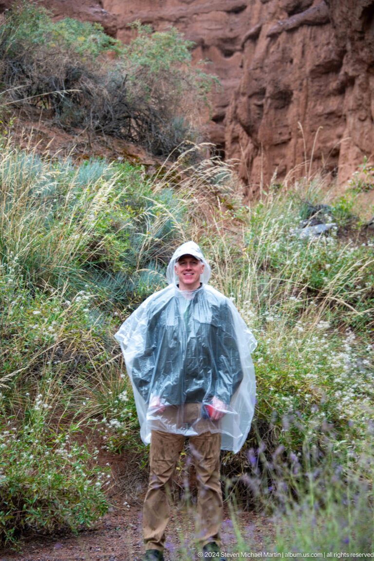 Visitor in clear rain poncho standing hands-on-hips.