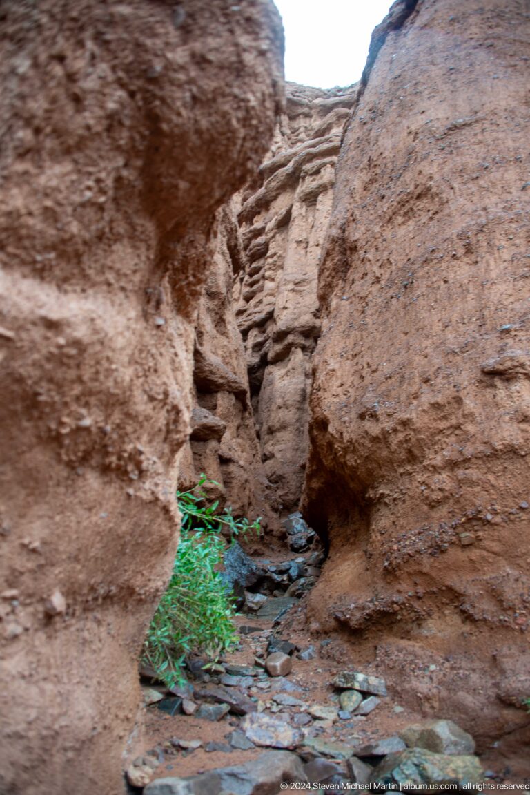 Tight slot-like passage between rough red walls.