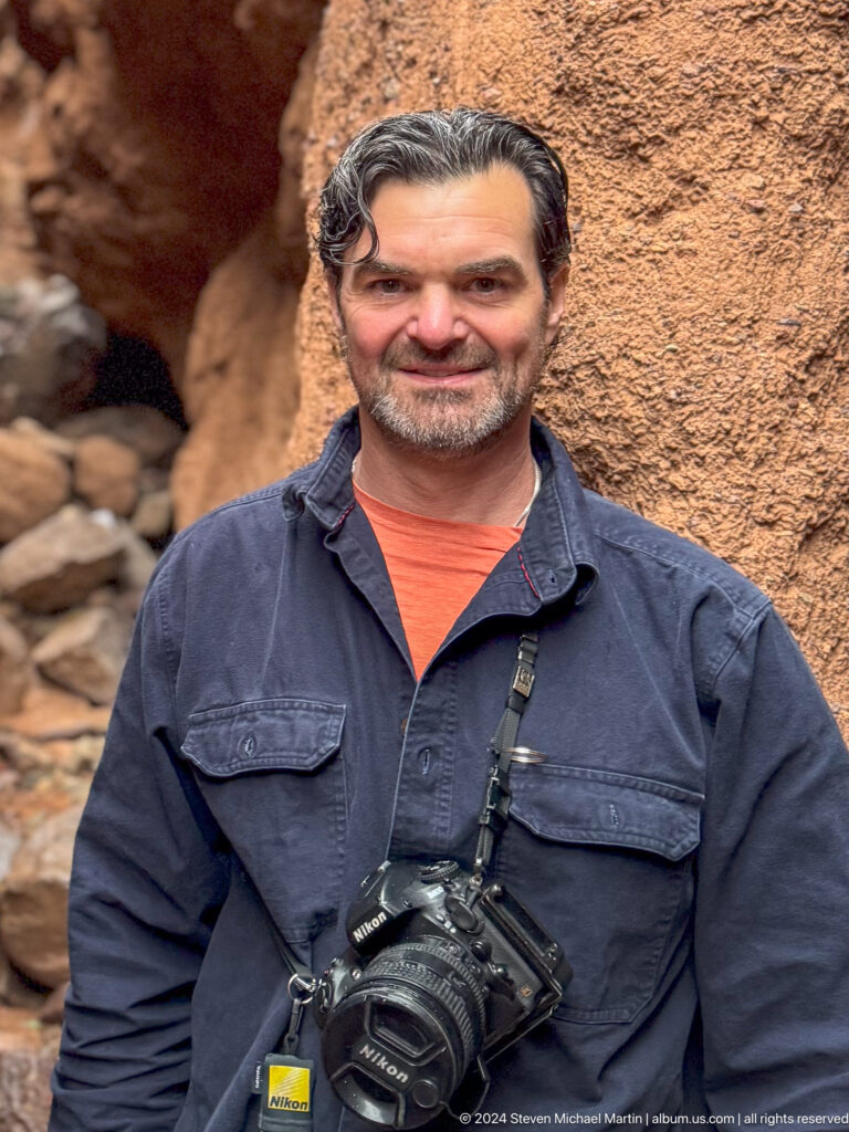 Close portrait of bearded man against red rock.