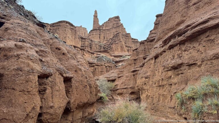 Narrow canyon basin with pointed spires and layered walls.