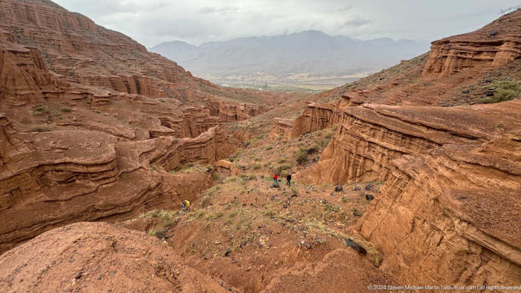 Wide valley opening beyond red canyon terraces.