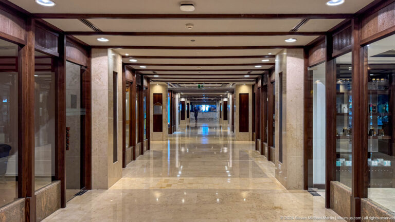 Long marble corridor with retail storefronts in Muscat, Oman.