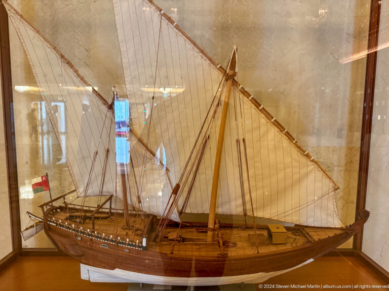 Model of wooden dhow with tall mast in Muscat, Oman.