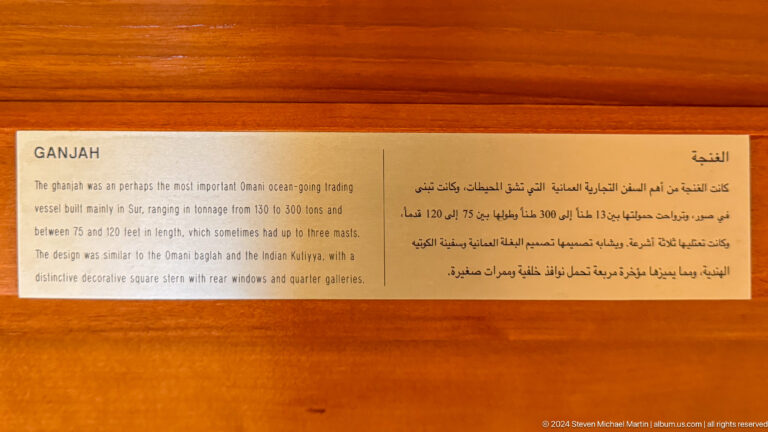 Orange bilingual museum label headed JAH in Muscat, Oman.