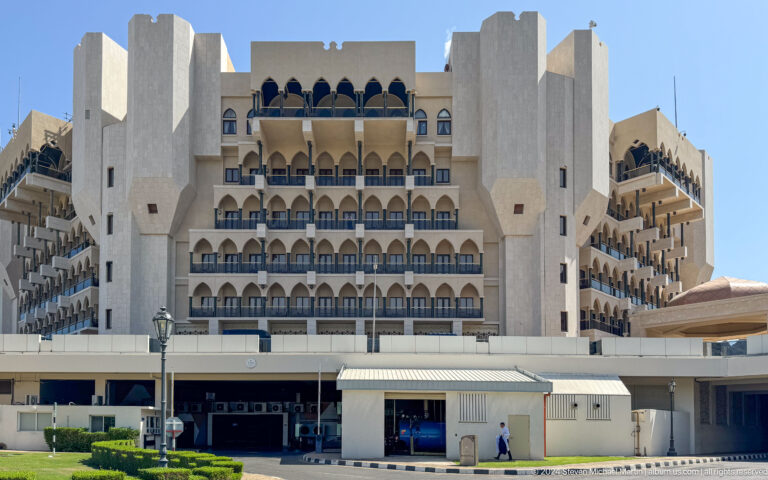 Large white hotel with stacked balconies in Muscat, Oman.