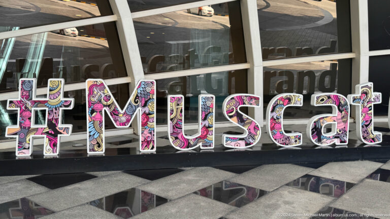 Muscat hashtag display with souvenir images in Muscat, Oman.