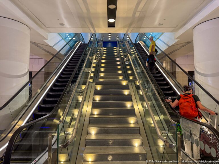 Illuminated escalator rising through mall in Muscat, Oman.