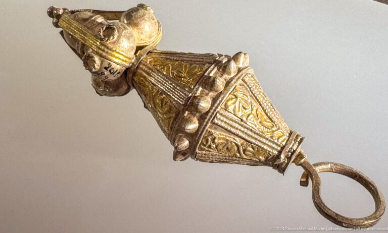 Gold-toned triangular pendant with granulation in Muscat, Oman.