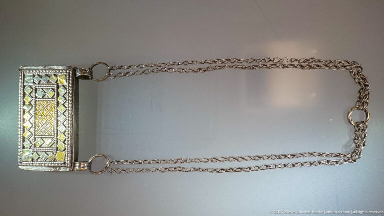 Long chain with rectangular decorated pendant in Muscat, Oman.