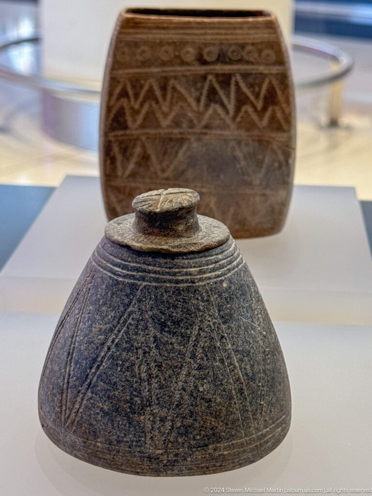 Dark stone vessel beside National Museum logo in Muscat, Oman.