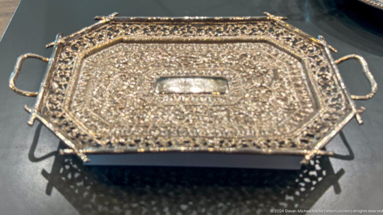 Rectangular metal or stone tray with dense geometric pattern in Muscat, Oman.