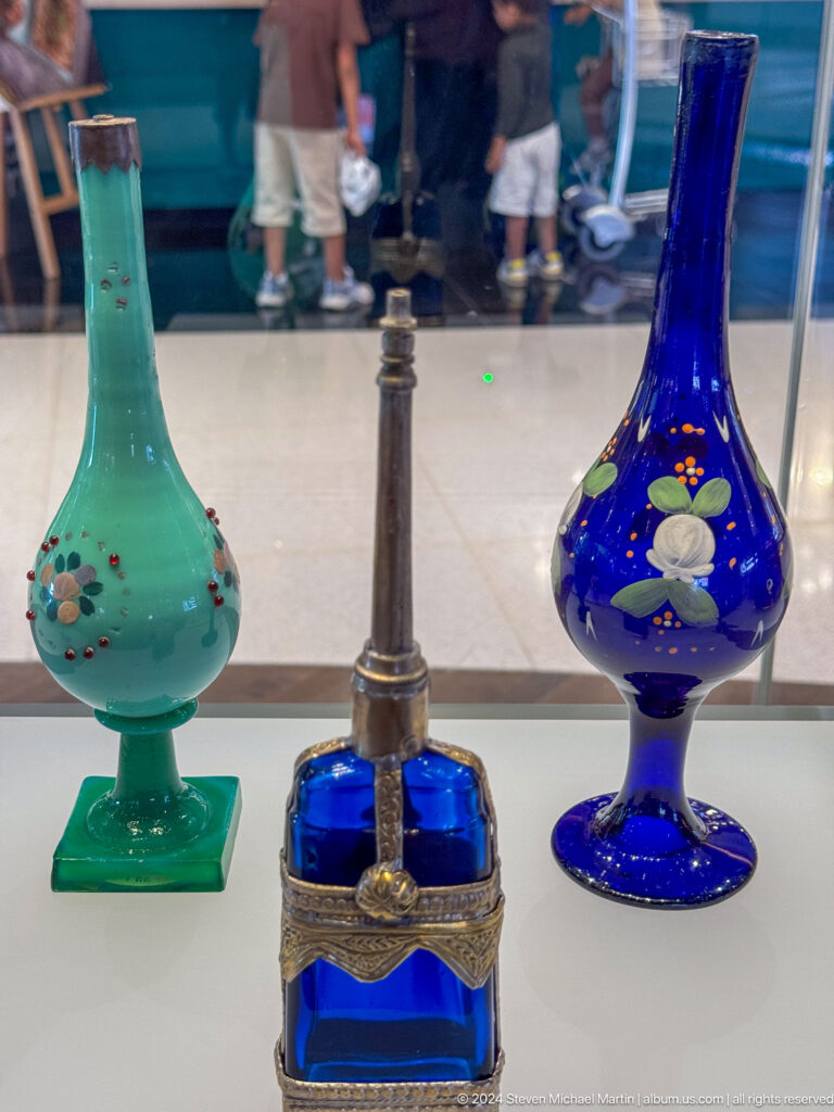 Turquoise and cobalt glass vessels with slender metal object in Muscat, Oman.
