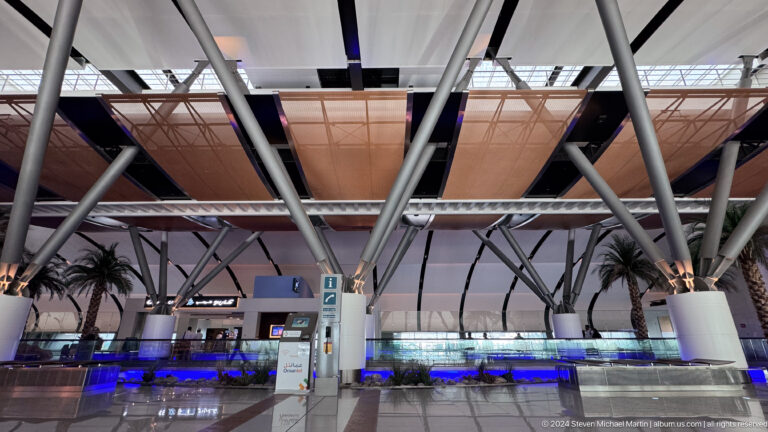 Airport departure hall beneath exposed roof trusses in Muscat, Oman.