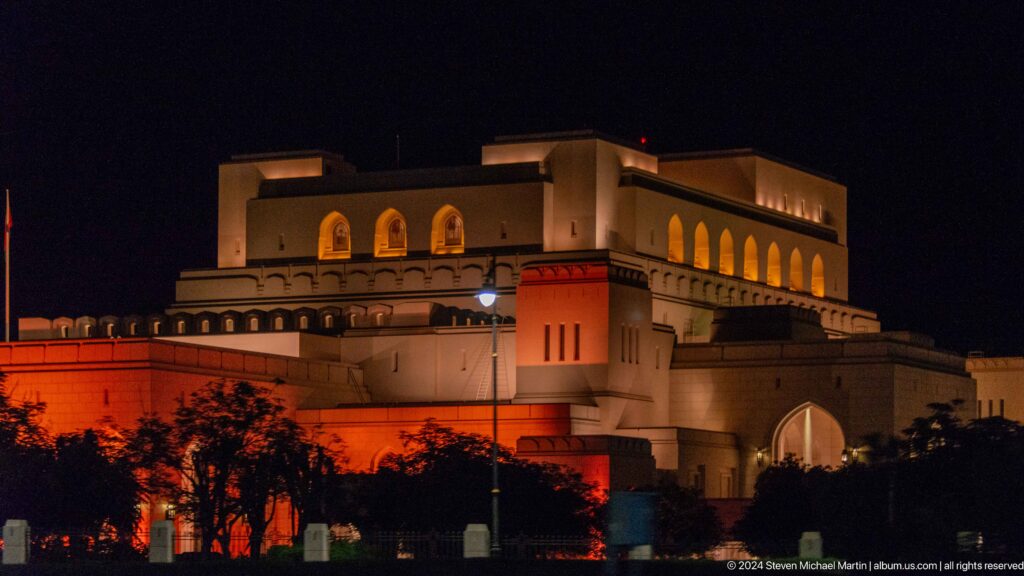 Royal Opera House glowing at night behind fountain spray in Muscat, Oman.